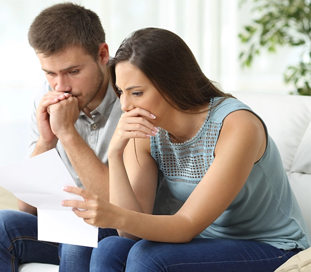 couple looking at piece of paper in home