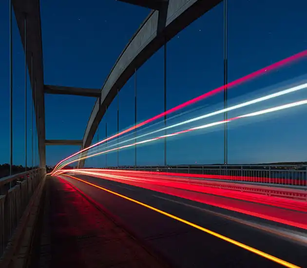 blurred car lights at night on a bridge