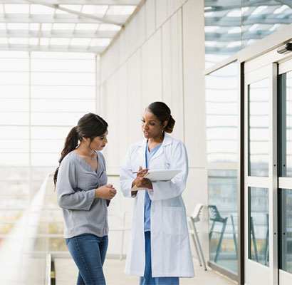 female doctor and patient talking in a modern hospital corridor