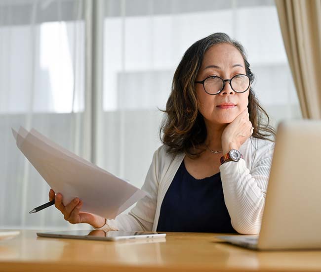 Mature woman  watching business training, online webinar on laptop computer