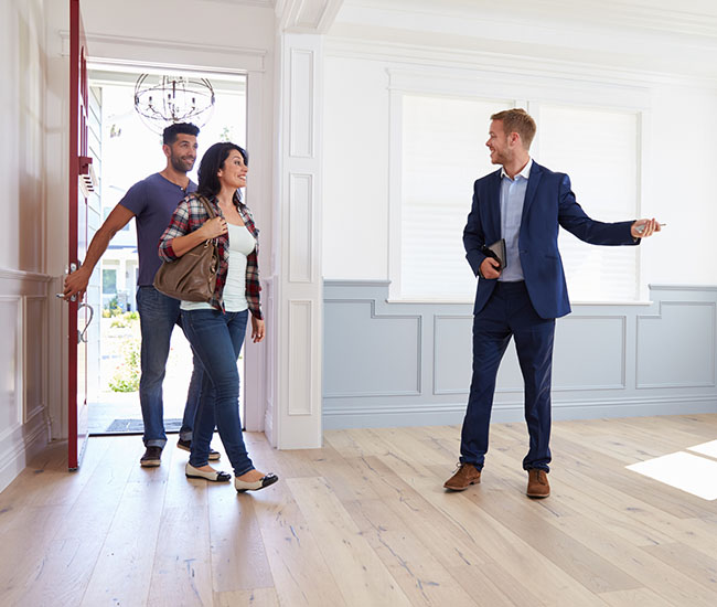 Real Estate Agent Showing Couple Around New Home