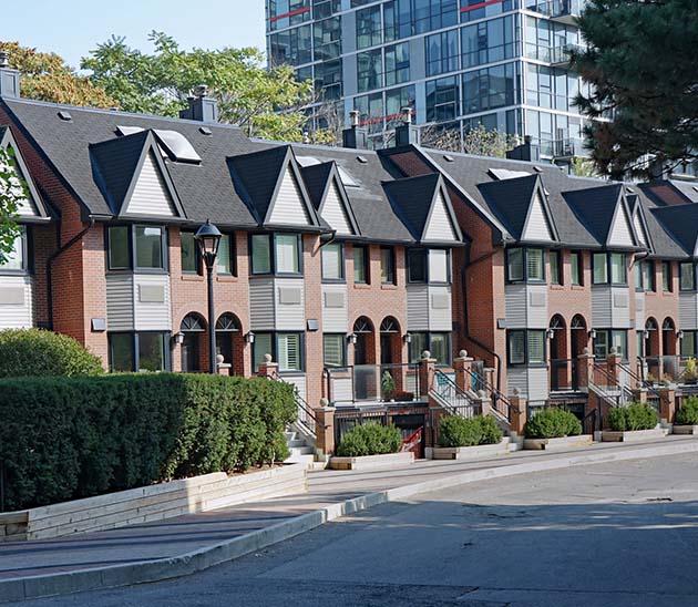 the importance of REBBA on building stronger communities - row of townhouses in a neighborhood with a condo building in the background