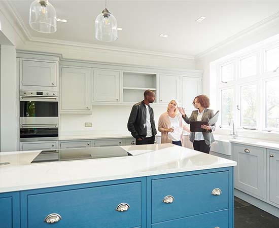 a REALTOR shows a couple around a home with new kitchen